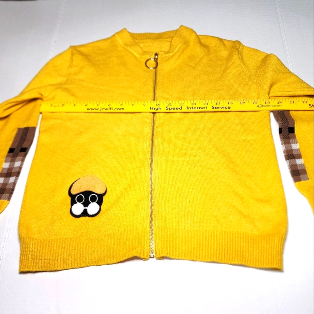 Yellow zip-up sweater with a cute little detail. Looks handmade.